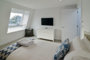 The second floor twin bedroom with chest of drawers and wall mounted tv