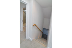 Stairs from the second to the first floor with one wooden handrail at The View