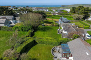 External aerial view over Zefyros showing adjacent properties and the ocean and Trevose Head in the background