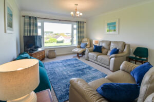 Lounge area at Zefyros with seating, tv and large window to the front garden
