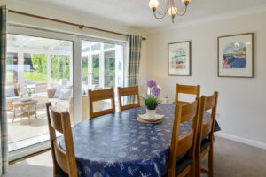 Dining table and chairs at Zefyros with doors into the conservatory