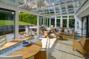 Sunny conservatory with seating at the rear of Zefyros with doors onto the patio and rear garden