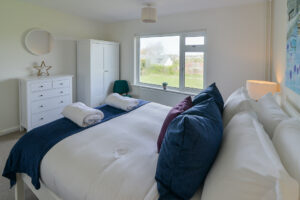 King bedroom with window to the front garden at Zefyros with chest of drawers and wardrobe