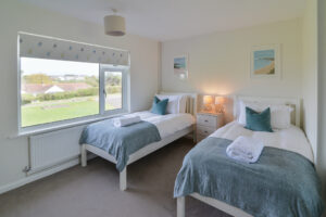 Twin bedroom with large window to the front garden at Zefyros