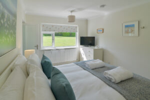 Ensuite master king bedroom with chest of drawers and tv at Zefyros