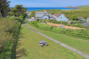 Aerial view of the communal grassed area at No 8 Sandhills with view towards Trevose Head