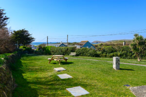 Grassed communal area at No 8 Sandhills with path leading to gate onto beach road