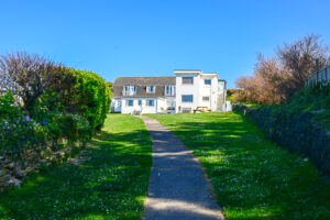 Communal grassed area and pathway to the beach road at No 8 Sandhills with adjacent apartments