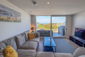 Open plan living area with balcony doors at No 2 Treglos
