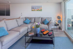 Large corner sofa with coffee table and balcony view at No 2 Treglos