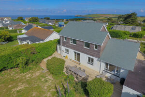Aerial view over the rear garden and views towards Trevose Head and the ocean.