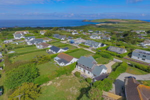 Aerial view over Whitehaven and nearby properties with the golf course and Trevose Head in the distance