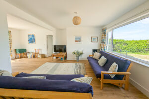Airy lounge area at Whitehaven with seating and large windo to the front garden