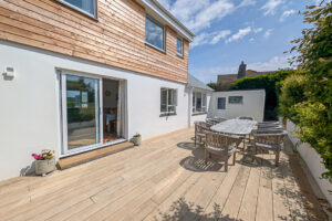 Rear decked area at Whitehaven with wooden outside dining furniture